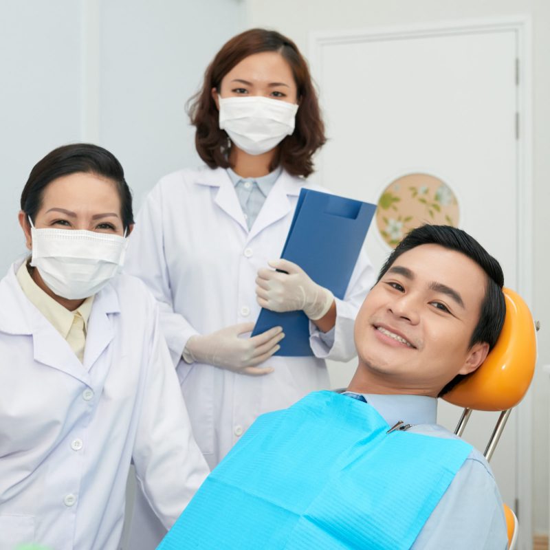 smiling-patient-and-doctors-in-dental-office-6XP9ZNT.jpg